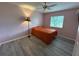 Cozy bedroom features a ceiling fan, window for natural light and laminate floors at 6082 Sw 104Th St, Ocala, FL 34476