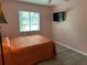 Bedroom featuring a single bed, TV, window with blinds and pink walls at 6082 Sw 104Th St, Ocala, FL 34476
