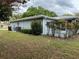 View of the home's exterior showcasing the yard, landscaping, and house paint color at 6082 Sw 104Th St, Ocala, FL 34476