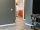 Hallway leading to a bedroom with an orange bed and a lamp at 6082 Sw 104Th St, Ocala, FL 34476
