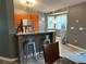 An open-concept kitchen features stainless steel appliances, a breakfast bar with seating, and a colorful border at 6082 Sw 104Th St, Ocala, FL 34476