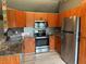 Stainless steel appliances, wooden cabinetry, and decorative backsplash in a modern kitchen at 6082 Sw 104Th St, Ocala, FL 34476