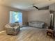 Bright living room featuring updated flooring, a ceiling fan, and natural light from a window at 6082 Sw 104Th St, Ocala, FL 34476