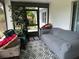 Relaxing sunroom with neutral furniture, patterned rug, leafy tree and peaceful backyard view at 6082 Sw 104Th St, Ocala, FL 34476