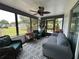 Inviting sunroom features neutral colors, a ceiling fan, and a wall of windows to let in natural light at 6082 Sw 104Th St, Ocala, FL 34476