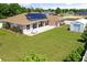A large green backyard featuring a storage shed, patio, solar panels and surrounding shrubbery at 6890 Sw 128Th Pl, Ocala, FL 34473
