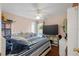 Bedroom with wood floors, ceiling fan, television, and blue and white striped bedding at 6890 Sw 128Th Pl, Ocala, FL 34473