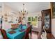 Bright dining room with a chandelier and large window overlooking the green yard at 6890 Sw 128Th Pl, Ocala, FL 34473