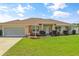 Inviting single-story home featuring meticulously landscaped front yard and large garage at 6890 Sw 128Th Pl, Ocala, FL 34473