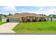 Charming single-story home featuring a lush green lawn, well-maintained landscaping, and an attached two-car garage at 6890 Sw 128Th Pl, Ocala, FL 34473