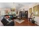 Inviting living room with wood floors, chandelier, and comfortable leather furniture at 6890 Sw 128Th Pl, Ocala, FL 34473