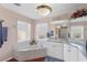 Well-lit main bathroom featuring a marble garden tub and white cabinets at 6890 Sw 128Th Pl, Ocala, FL 34473