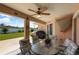 Covered patio with ceiling fan, glass table, and chairs overlooking the backyard at 6890 Sw 128Th Pl, Ocala, FL 34473