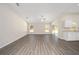 Open-concept living room with vaulted ceilings, wood-look floors, and access to a kitchen and outdoor space at 7798 Sw 134Th Ave, Dunnellon, FL 34432