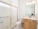 This bright bathroom offers a glass-door shower, tile flooring, and a wood vanity at 8218 Sw 92Nd Cir, Ocala, FL 34481
