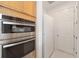 Kitchen appliances featuring stainless steel built-in oven and microwave next to refrigerator and door at 8218 Sw 92Nd Cir, Ocala, FL 34481