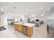 Open-concept kitchen featuring a large island with seating and stainless steel appliances, flowing into the living area at 8218 Sw 92Nd Cir, Ocala, FL 34481