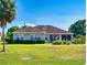 View of the back of the home with manicured lawn, screened patio, and mature landscaping at 9172 Se 130Th Loop, Summerfield, FL 34491