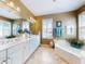 Bright bathroom with a double sink vanity, soaking tub, walk-in shower and plantation shutters at 9172 Se 130Th Loop, Summerfield, FL 34491