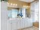 Bathroom featuring a vanity with double sinks, a large mirror and updated lighting at 9172 Se 130Th Loop, Summerfield, FL 34491