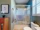Bathroom featuring a shower with glass doors, and tiled floors at 9172 Se 130Th Loop, Summerfield, FL 34491