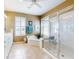 Bright bathroom with a double sink vanity, soaking tub, walk-in shower and plantation shutters at 9172 Se 130Th Loop, Summerfield, FL 34491