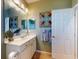 Bathroom with a well-lit vanity, tiled floors, and colorful artwork at 9172 Se 130Th Loop, Summerfield, FL 34491