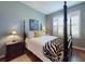 Cozy bedroom featuring a four poster bed, zebra blanket, and bright window at 9172 Se 130Th Loop, Summerfield, FL 34491