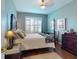 Charming bedroom with four poster bed, wooden floors, and bright window at 9172 Se 130Th Loop, Summerfield, FL 34491