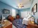Comfortable bedroom featuring a ceiling fan, a stylish rug, and ample natural light from window at 9172 Se 130Th Loop, Summerfield, FL 34491