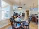 Inviting dining room with a glass table, wooden chairs, and views into the living room and kitchen at 9172 Se 130Th Loop, Summerfield, FL 34491