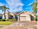 Beautiful single-Gathering home with lush landscaping, a brick driveway, and a two-car garage at 9172 Se 130Th Loop, Summerfield, FL 34491