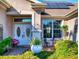 Charming home entrance with a decorative door, beautiful plants, and a cozy sitting area at 9172 Se 130Th Loop, Summerfield, FL 34491