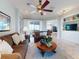 Comfortable living room with ceiling fan, neutral decor, and seamless flow into other living spaces at 9172 Se 130Th Loop, Summerfield, FL 34491