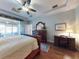 An elegant main bedroom with a ceiling fan, wood floors, and sliding doors to the patio at 9172 Se 130Th Loop, Summerfield, FL 34491