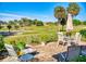 Brick patio with comfortable seating, a table with an umbrella, and views of the golf course at 9172 Se 130Th Loop, Summerfield, FL 34491