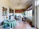 Cozy sunroom featuring wicker furniture, a ceiling fan, tile floors and large windows at 9172 Se 130Th Loop, Summerfield, FL 34491