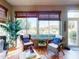 Bright sunroom with cozy wicker furniture, beautiful plants, and a view of the lush outdoor landscape at 9172 Se 130Th Loop, Summerfield, FL 34491