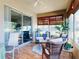 Sunroom with wicker furniture, tile floors, ceiling fan, large windows and sliding glass door at 9172 Se 130Th Loop, Summerfield, FL 34491