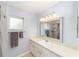 Well-lit bathroom with a single sink, large mirror, and a shower with curtain at 9741 Sw 97Th Ln, Ocala, FL 34481