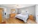 Bright bedroom featuring wood floors, ceiling fan, and a large dresser with mirror at 9741 Sw 97Th Ln, Ocala, FL 34481