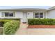 Close-up of the front entrance featuring a well-manicured garden and walkway at 9741 Sw 97Th Ln, Ocala, FL 34481