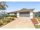 A well-maintained single-story home with a screened garage, complemented by mulch and green landscaping at 9741 Sw 97Th Ln, Ocala, FL 34481