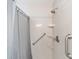 Shower stall featuring grab bars and built-in shelving for added convenience at 9741 Sw 97Th Ln, Ocala, FL 34481