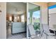 View from a sliding glass door onto a screened lanai, featuring seating and a view of the outdoor landscape at 9856 Sw 100Th Ter, Ocala, FL 34481
