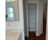 The bathroom features a built-in linen closet, granite vanity with sink, mirror and bath-shower combo in view at 11014 Sw 73Rd Cir, Ocala, FL 34476