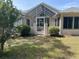 Charming home exterior with an enclosed patio, lush landscaping, and a well-maintained lawn at 11014 Sw 73Rd Cir, Ocala, FL 34476
