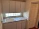 Functional laundry room featuring a sink, cabinet storage, and natural light from window at 11014 Sw 73Rd Cir, Ocala, FL 34476