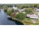 Aerial view showcasing a waterfront property featuring lush trees and a private dock at 12180 Maple St, Dunnellon, FL 34432