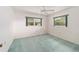 Neutral bedroom featuring large windows with green trim, plush blue carpeting and white walls at 12180 Maple St, Dunnellon, FL 34432